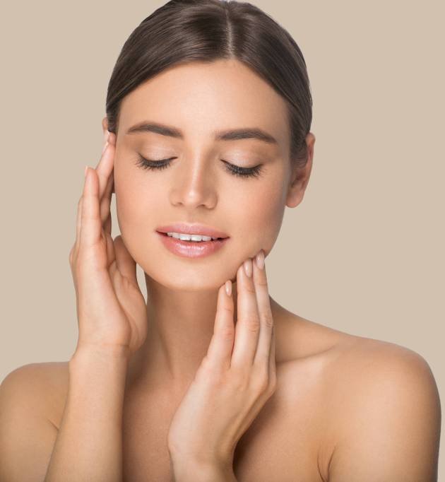 Woman beauty portrait touching her face. Color background. Brown.